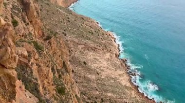 Çarpıcı, pitoresk kayalık bir sahil şeridi kristal turkuvaz suları ve uzak, görkemli kaya oluşumları içerir.