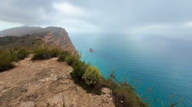 Bu nefes kesici kıyı manzarası güzel bir şekilde gökyüzünün altındaki dingin okyanus manzarasını sergiliyor.