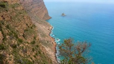 Bu pitoresk kıyı manzarasında sakin turkuaz sulara bakan nefes kesici uçurumlar.