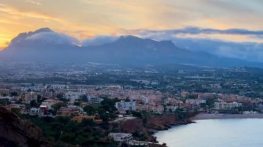 Gün batımında dağlarla güzel sahil manzarası, doğayı aydınlatan sükunet ve manzaralı güzellik..