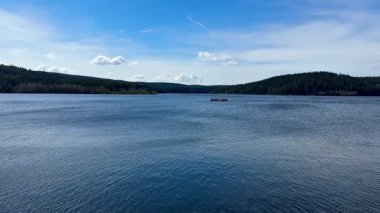 Göz kamaştırıcı bir göl manzarası yemyeşil ile çevrili, canlı, renkli bir gökyüzü ile tamamlanmış, doğa meraklıları için ideal.