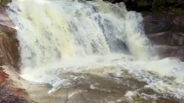 Muhteşem bir şelalenin engebeli kayaların üzerinde şelalenin serinletici manzarası doğal bir manzara yaratıyor.