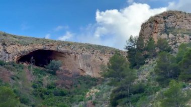 Canlı yeşillikler ve manzaralı tepelerle çevrili nefes kesici bir mağarayı keşfetmek için maceraya atılın.