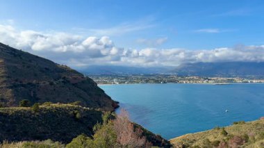 Nefes kesici bir kıyı manzarası görkemli dağlar, kristal berrak su ve güzel canlı gökyüzü.