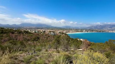 Güzel bir şekilde sergilenen nefes kesici kıyı manzarası. Her yerde yemyeşil bitki örtüsü ve köpüklü sular.