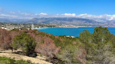 Bu nefes kesen kıyı manzarası canlı ağaçlara, dingin sulara ve görkemli dağlara sahip, nefes kesici bir manzara yaratıyor.