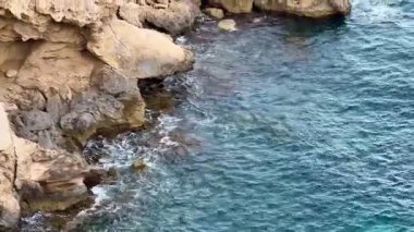 Engebeli bir kayalık kıyı şeridi sakin okyanus sularıyla buluşur, şaşırtıcı güzellikler ve cazibeler sergiler.