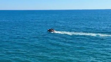 Güneşli bir günde sakin mavi okyanus sularında jet ski yapmanın coşkulu deneyimine dalın.