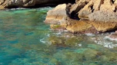 Engebeli kıyı şeridinin çarpıcı manzarası berrak turkuaz sularla buluşup nefes kesici bir manzara sunuyor.