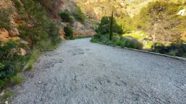 Dolambaçlı bir çakıl yolu, yemyeşil tepeler ve tepemizde parlak mavi bir gökyüzü barındıran inanılmaz manzaralı bir manzara.