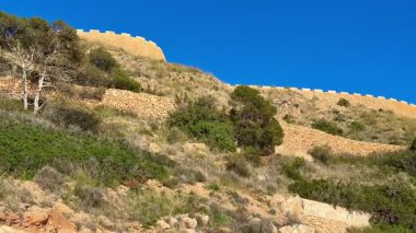 İkonik taş duvarları ve yemyeşil yeşillikleri olan nefes kesici kıyı manzaralarını keşfetmek için bir maceraya atılın.
