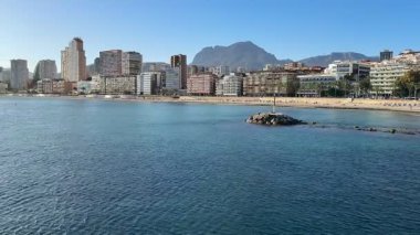 Gerçekten çarpıcı bir kıyı manzarası sakin sulara karşı güzel bir tezat oluşturan canlı bir şehir silueti sergiliyor.