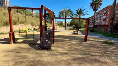 Güneşli bir ortamda salıncak ve tırmanma faaliyetleri sunan bu canlı ve renkli oyun alanını keşfedin.