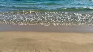 Güneşli bir plajda, huzur ve rahatlama hissi uyandıran yumuşak dalgaların inanılmaz güzelliğini yakalayın.