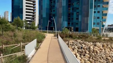 Şehir yaşamından huzurlu bir kaçış için şehir tasarımını yeşillikle harmanlayan modern mimariye yakın manzaralı bir yürüyüş.