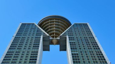 Modern bir tasarıma ve gökyüzüne hayran olacak bir gözlem güvertesine sahip iki yüksek binanın çarpıcı görüntüsü.