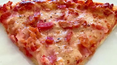 Lezzetli bir peynirli pizzanın canlı yakın plan görüntüsü. Lezzetli pastırma ve taze otlarla süslenmiş.