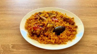 Lezzetli ve canlı bir tabak Jollof pilavı, güzel bir tavuk ve bir dizi taze sebze.