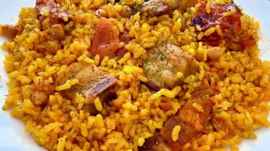 Görsel olarak çekici bir tabak lezzetli et parçaları ve renkli taze sebzeli baharatlı pirinç.