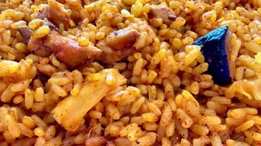 Canlı bir tabak Jollof pilavı, içinde taze tavuk ve renkli sebzeler var, her yemek için mükemmel.