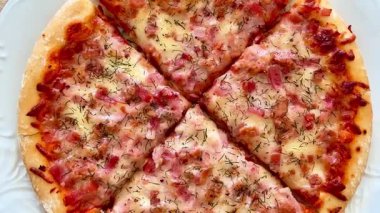 Erimiş peynirli, lezzetli jambonlu ve otlu ağız sulandıran bir pizza. Her yemek için mükemmel.
