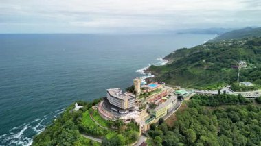 Hava manzarası okyanus kıyısında lüks bir tatil köyü sergiliyor. Etrafı yemyeşil, canlı yeşilliklerle çevrili.