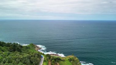 Bu çarpıcı manzara engin okyanusu, bereketli yuvarlanan tepeleri ve huzurlu bir kıyı yolunu güzel bir şekilde yansıtıyor.