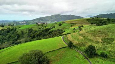 Muhteşem hava manzarası, yuvarlanan yeşil tepeler, dönen yollar, hepsi güzel bulutlu bir gökyüzünün altında.