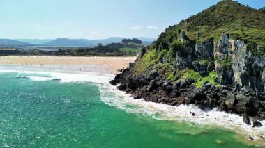 Görkemli uçurumların, pırıl pırıl turkuaz suların ve yumuşak, davetkar kumlu sahillerin olduğu nefes kesici bir sahil sahnesi.