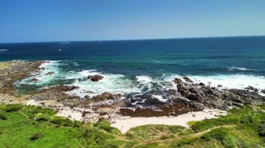 Huzurlu bir sahil manzarasında dalgaların engebeli kayalara çarptığı manzaralı okyanus manzarasını deneyin.