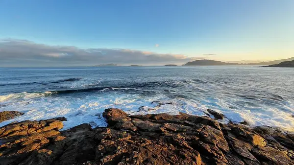 Güneşin doğuşunda kayalık kıyılara çarpan dalgaların nefes kesici görüntüsü doğanın sükunetini yakalıyor..