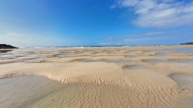 Çok güzel gelgit desenleri olan çarpıcı kumlu bir sahil, doğa severler ve tatil kaçamakları için ideal.