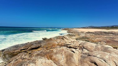 Göz kamaştırıcı bir sahil manzarası muhteşem kayalar, güzel turkuaz su ve yukarıda el değmemiş berrak gökyüzü.