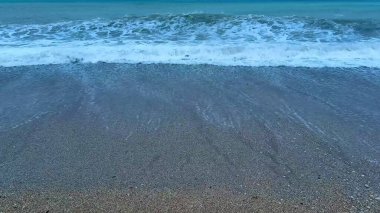 Alacakaranlık gökyüzü altındaki plaj dalgalarının huzur verici güzelliğini tecrübe et, rahatlama ve meditasyon için mükemmel..