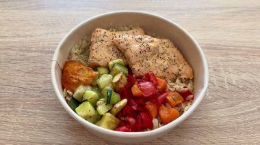 Lezzetli ve besleyici bir somon kasesini deneyin. Tüylü pirinç, canlı taze sebzeler ve lezzetli bir sosla doldurulmuş.