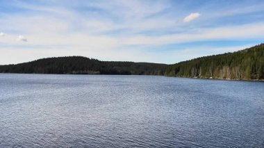 Yoğun ormanlar ve açık gökyüzü ile çevrili huzurlu bir göl manzarası doğa severler için mükemmel.
