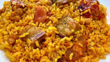 Görsel olarak çekici bir tabak lezzetli et parçaları ve renkli taze sebzeli baharatlı pirinç.