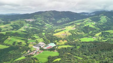 Bereketli ormanların yanında tarımın güzelliğini gösteren yemyeşil bir dağ manzarasının çarpıcı hava manzarası.