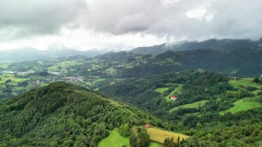 Nefes kesici bir kuş bakışı çarpıcı bulutlu gökyüzünün altında canlı yeşil tepeleri ve güzel vadileri gösterir.