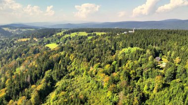 Nefes kesici bir hava manzarası canlı ve yemyeşil bir ormanı sergiliyor. Yuvarlanan tepelerin arasında güzelce yerleşmiş.