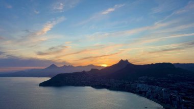 Şok edici günbatımı dağları ve kıyıları aydınlatıyor, benzersiz güzellikler sergiliyor.