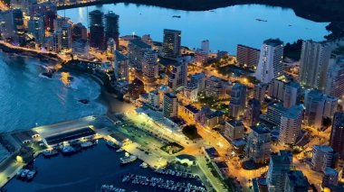 Geceleri nefes kesici bir hava manzarası sunar. Sahil kenti ışıkları sakin sularda güzel bir şekilde parıldar.