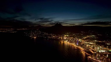 Bu güzel alacakaranlık manzarası çarpıcı şehir ışıklarıyla karışık bir şekilde aydınlatılmış canlı bir kıyı şehrini gözler önüne seriyor.