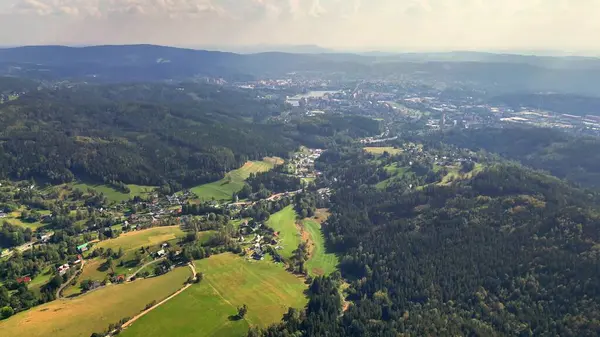 Hava manzarası, doğanın içine nazikçe yerleşmiş sakin bir kasabayla canlı yeşil bir manzara yakalar.