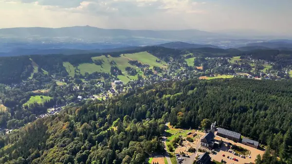 Nefes kesici bir hava görüntüsü, kıvrımlı tepelerin arasına kurulmuş canlı ve renkli bir köy yakalıyor.