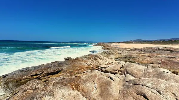 Göz kamaştırıcı bir sahil manzarası muhteşem kayalar, güzel turkuaz su ve yukarıda el değmemiş berrak gökyüzü.
