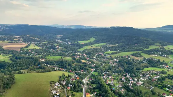 Göz kamaştırıcı bir hava manzarası canlı yeşil tepeleri ve yakınlardaki huzurlu köyleri güzel bir şekilde gözler önüne seriyor.