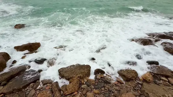 Güzel dalgalar zarif bir şekilde kayalık kıyılara çarpar. Doğanın nefes kesici gücünü ve sükunetini gösterir.