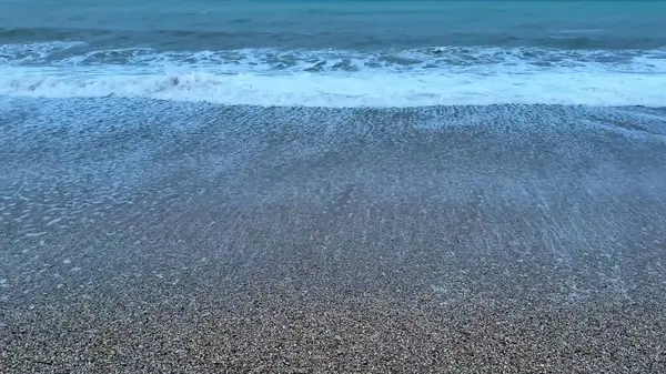 Kendini dingin ve dingin bir güzelliğe daldır. Hafif dalgaların alacakaranlıkta yavaşça kıyıya vurması.