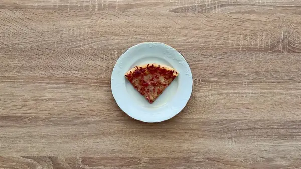 Lezzetli, ağız sulandıran bir dilim pizza zarif bir tabakta sunuluyor, tutkulu yemek severler için ideal.